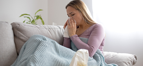 Flu-vaccine-available-in-Hampton-Wick-for-woman-with-the-flu-blowing-nostrils.