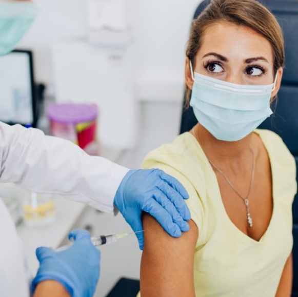 A-Woman-Wearing-Mask-Receiving-Vaccine-on-her-Han